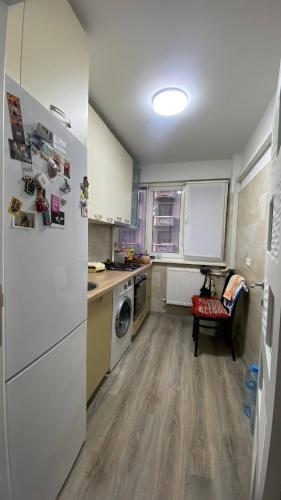 a kitchen with a white refrigerator and a dishwasher at Private Room in city centre KM0 in Bucharest