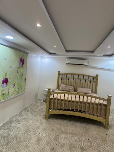 ein Schlafzimmer mit einem Bett und einem Wandgemälde in der Unterkunft شاليه 1 in Al Ḩazm