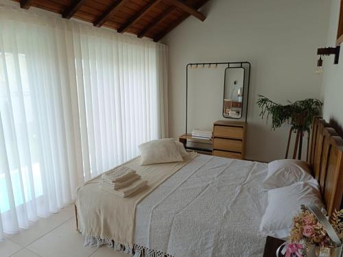 a bedroom with a large bed and a mirror at Celeiro do Carvalho in Estela