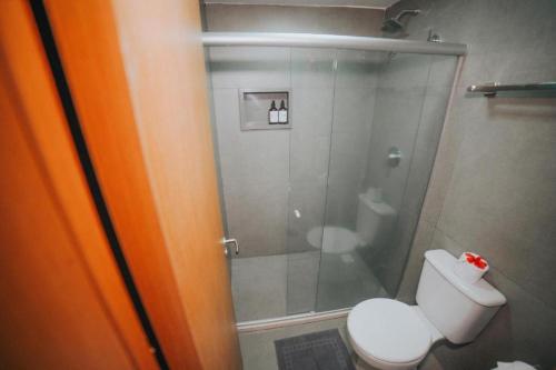 a bathroom with a toilet and a glass shower at Pousada Alto Mar in Fernando de Noronha