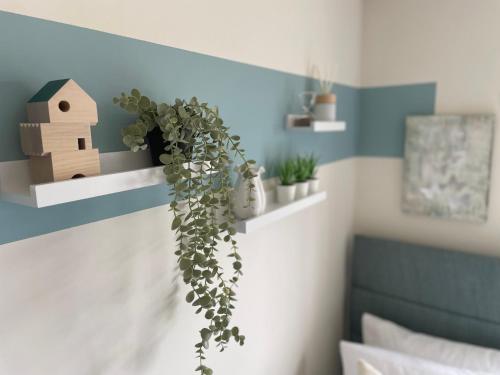 a bedroom with a blue and white wall with plants at 3-Bedroom Luxury Stay With FREE Parking in Market Harborough