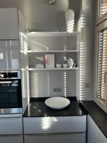 a kitchen with white cabinets and a black counter top at Traumhafte Wohnung mit Neckarblick und Balkon in Eberbach