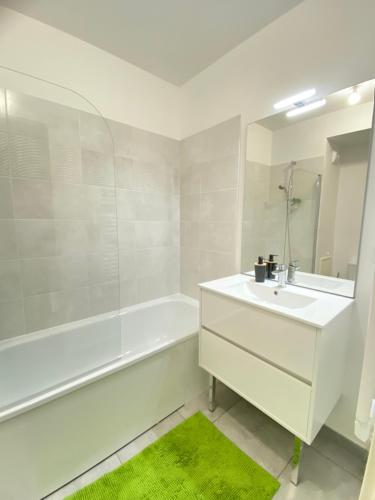 une salle de bain blanche avec un lavabo et une baignoire dans l'établissement Triplex neuf avec toit-terrasse au pied du Métro - 10min PARIS EXPO - 4 rooms 6 beds, à Bagneux