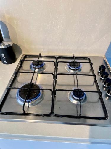 a stove top oven with four burners on it at 3-Bedroom Luxury Stay With FREE Parking in Market Harborough