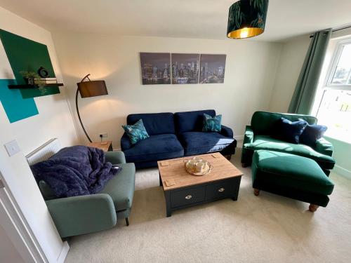 a living room with a blue couch and two chairs at 3-Bedroom Luxury Stay With FREE Parking in Market Harborough