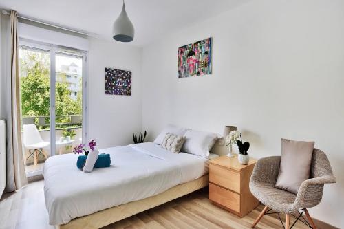 グルノーブルにあるSoyeux de la bruyère/ grenoble*parking gratuitのベッドと椅子のある白い寝室