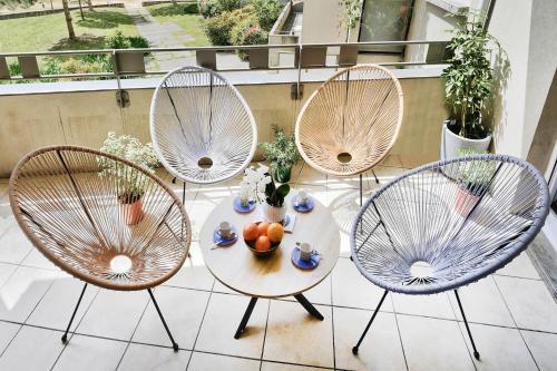 trois chaises et une table avec des fruits sur un balcon dans l'établissement Soyeux de la bruyère/ grenoble*parking gratuit, à Grenoble