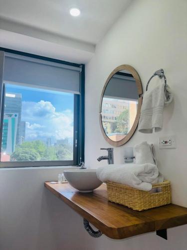 a bathroom with a sink and a mirror at Hotel Bambu Milla De Oro in Medellín