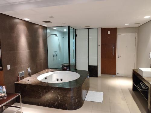 a bathroom with a sink and a bath tub at Motel Confidence in Santo André