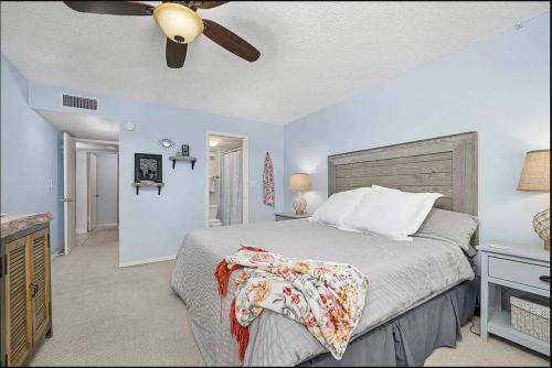 een slaapkamer met een bed en een plafondventilator bij Pelican Inlet-Cozy Beach Condo! in St. Augustine