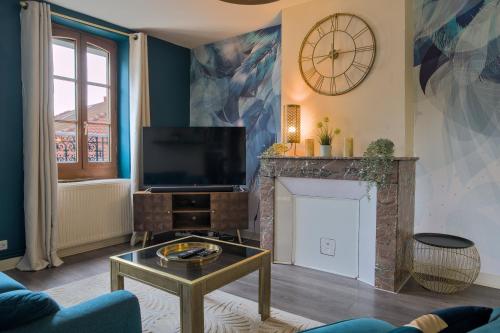 un salon avec une télévision et une cheminée dans l'établissement UnSejourAMetz - Le paon d'or - 3 chambres, à Metz