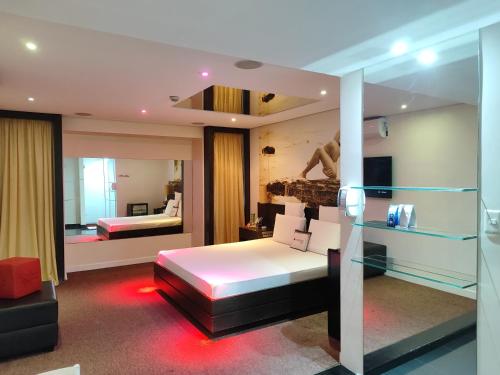 um quarto de hotel com uma cama e um espelho em Motel Confidence em Santo André