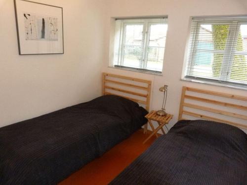 1 dormitorio con 2 camas y 2 ventanas en Holiday apartment Kröte 5, 