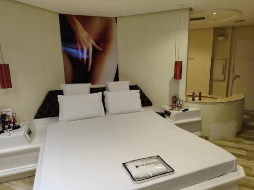 a bedroom with a white bed and a large mirror at Motel Confidence in Santo André