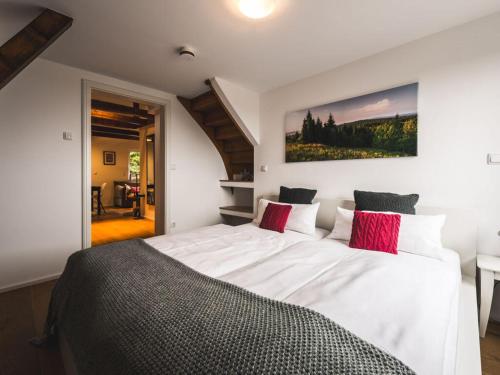 een slaapkamer met een groot wit bed met rode kussens bij Holiday apartment Ahornspitze in Kurort Bärenburg