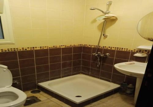a bathroom with a shower and a toilet and a sink at Blumar Sidi Abdel Rahman 2 bedrooms Chalet North Coast in El Alamein