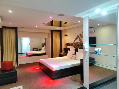 a hotel room with a bed and a mirror at Motel Confidence in Santo André