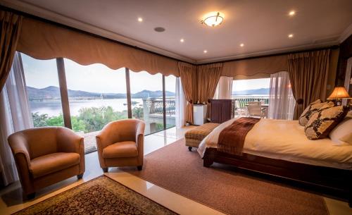 a bedroom with a large bed and a large window at Château La Mer Exclusive Guesthouse & Spa in Hartbeespoort