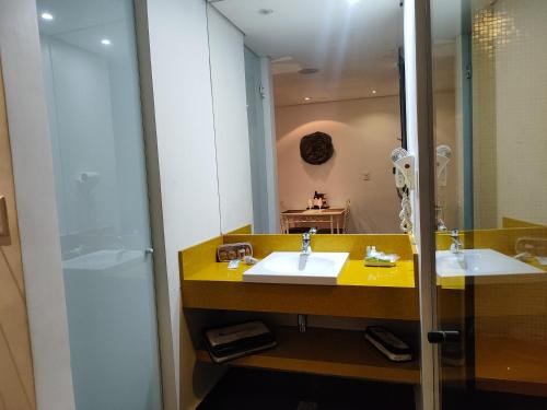 La salle de bains est pourvue de 2 lavabos et d'un grand miroir. dans l'établissement Motel Confidence, à Santo André