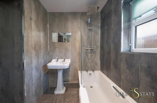 uma casa de banho com um lavatório e uma banheira e um lavatório em Luke Stays Bainbridge street, Durham em Leamside
