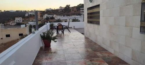 a balcony with a table and chairs on a building at استديوهات الجبل in Jerash