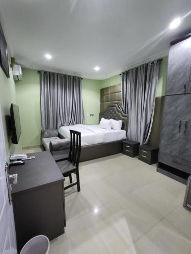 Habitación de hotel con cama y escritorio en Cozy Residence Abuja, en Abuja
