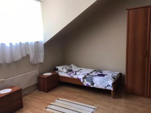 a small bedroom with a bed and a staircase at Apartman Spasic in Ribarska Banja