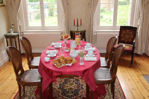 een tafel met een rode tafelkleed en voedsel erop bij Le Clos Boutenelle in Éperlecques