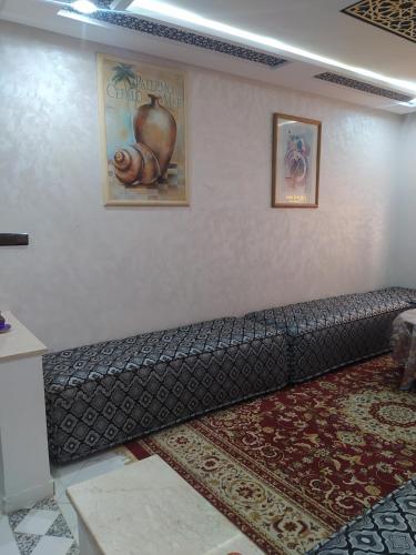 a couch against a wall in a room at Rooms in shared apartment close to CMN-Airport in Dah Hammou Ben Cheïkh