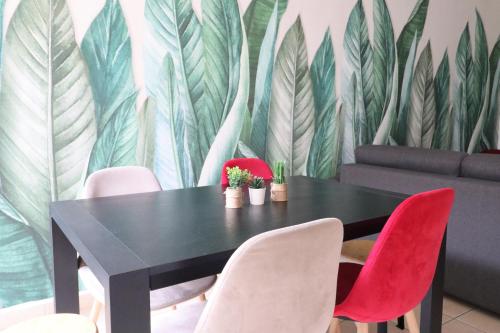 une salle à manger avec une table noire et des chaises rouges dans l'établissement Plaza Vienne 01, à Montévrain