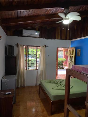 Corcovado Hostel في بويرتو خيمينيز: غرفة نوم بسرير ومروحة سقف
