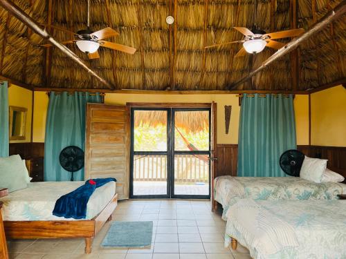 a room with two beds and a ceiling fan at Hotel Del Rio in San Pedro