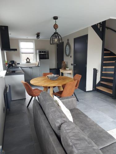 a living room with a couch and a table at Vakantiewoning Nimmerdor, Grijpskerke, dichtbij strand en stad in Grijpskerke