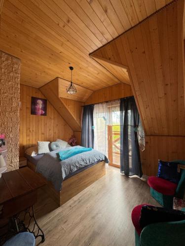 um quarto com uma cama e um tecto de madeira em Domki całoroczne KATRINA em Krynica Morska