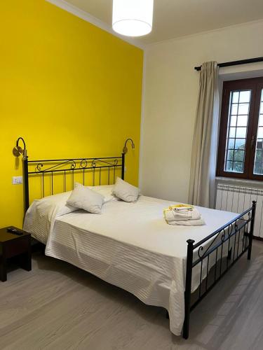 a bedroom with a large bed with a yellow wall at B&b filì Al casale 1121 in Rome