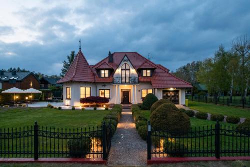 a house with a fence in front of a yard at Willa Aga in Dębki