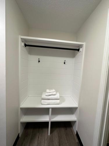 - un placard blanc avec 3 serviettes sur une étagère dans l'établissement Green Harbor Hotel, à Marshfield
