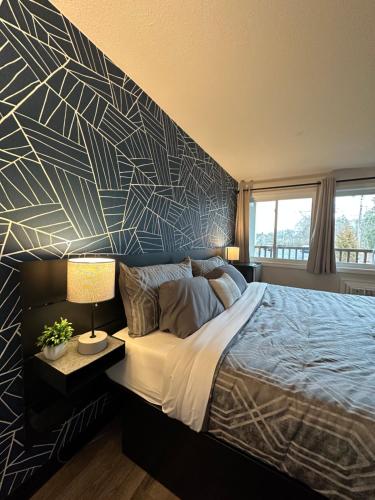 a bedroom with a large bed with a geometric wall at Green Harbor Hotel in Marshfield