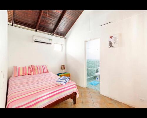 1 dormitorio con 1 cama y baño con ventana en bungalow cactus frente ala playa, en Cahuita