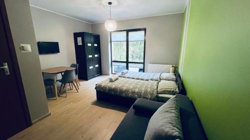 um quarto com uma cama, um sofá e uma mesa em Willa Bursztynowa em Kąty Rybackie