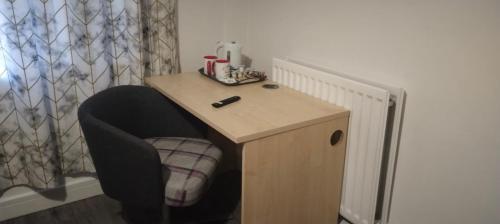 a small table with a chair and a desk at White House Ensuite double bedroom in Warrington