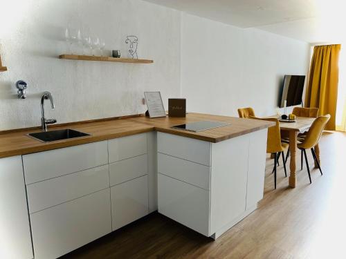uma cozinha com um balcão com um lavatório e uma mesa em Ferienwohnung Sonneck em Oberstaufen