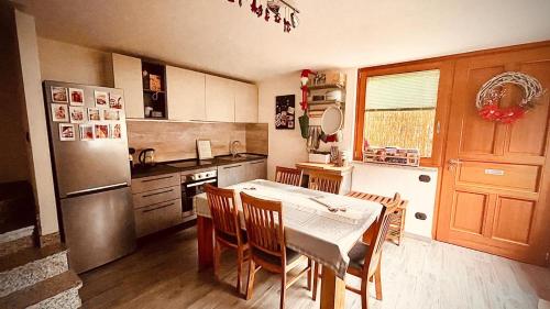 a kitchen with a table with chairs and a refrigerator at La Sellerie in Nus