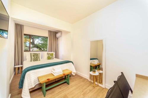 a small bedroom with a bed and a television at Rizzu Marina Hotel in Balneário Camboriú