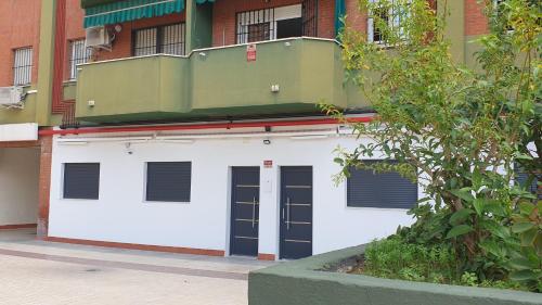 eine weiße Garage mit zwei Türen und einem Gebäude in der Unterkunft Sevilla Urban Flat in Sevilla