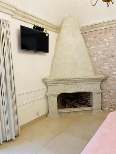 a living room with a stone fireplace with a flat screen tv at Mansión Leonor in Bernal