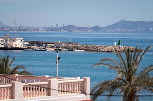 a view of a body of water with buildings and palm trees at Rooms by JovA in El Campello