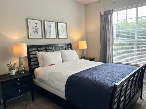 a bedroom with a bed with two lamps and a window at Hidden Gem at Med Center 2BR & 2BA Apartment in Houston