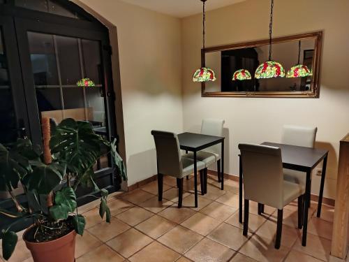 un comedor con 2 mesas y sillas y una planta en Elodie's Country House - Alojamento Local, en Grândola