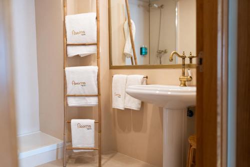 y baño con lavabo, espejo y toallas. en Rooms by JovA en El Campello
